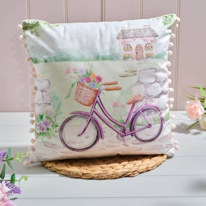 Coussin en velours polyester imprimé scène de vélo carré de jardin de cottage avec pompons et fermeture éclair pour la vente par Langs