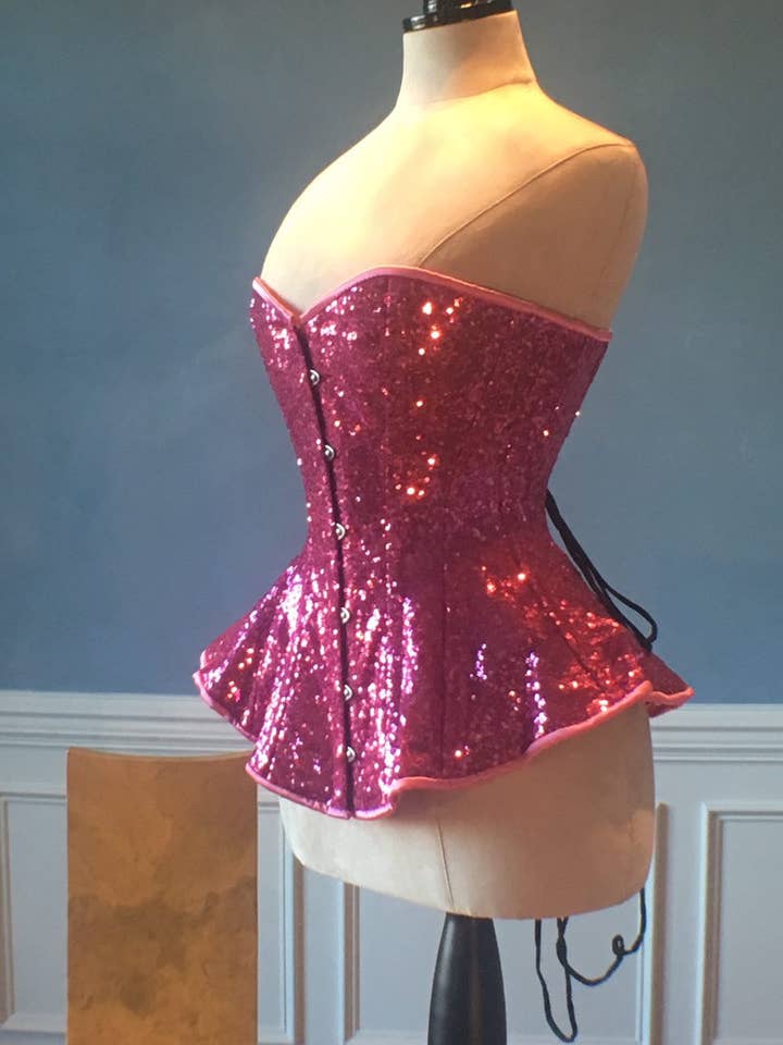 The Ramona Corset. Bespoke high quality authentic peplum style corset from pink sequins on steel bones for wholesale by corsettery