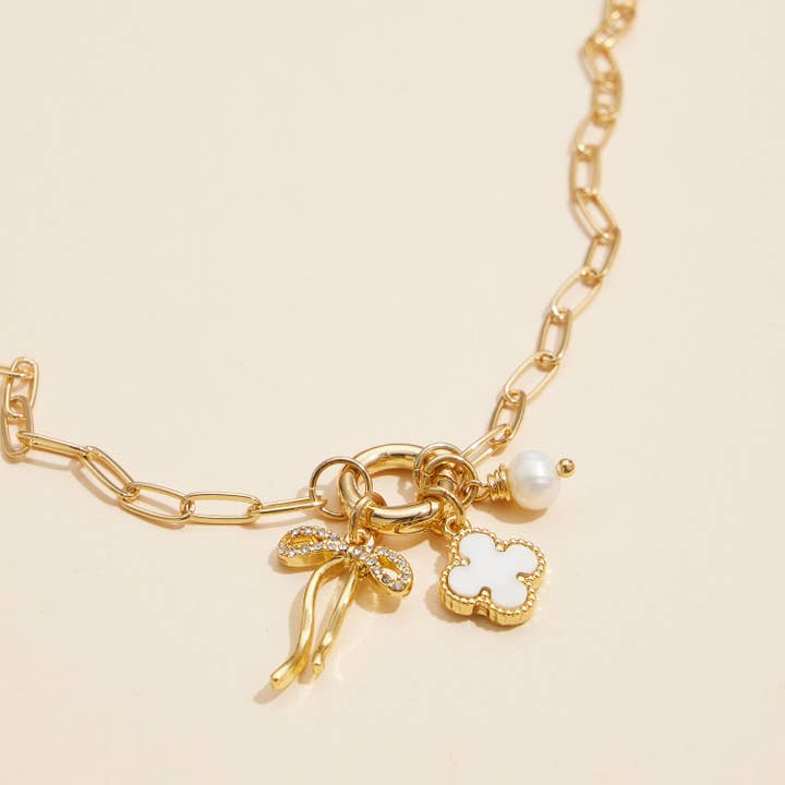 Gold Dipped Bow Charm Necklace with Clover and Pearl for wholesale on Faire2