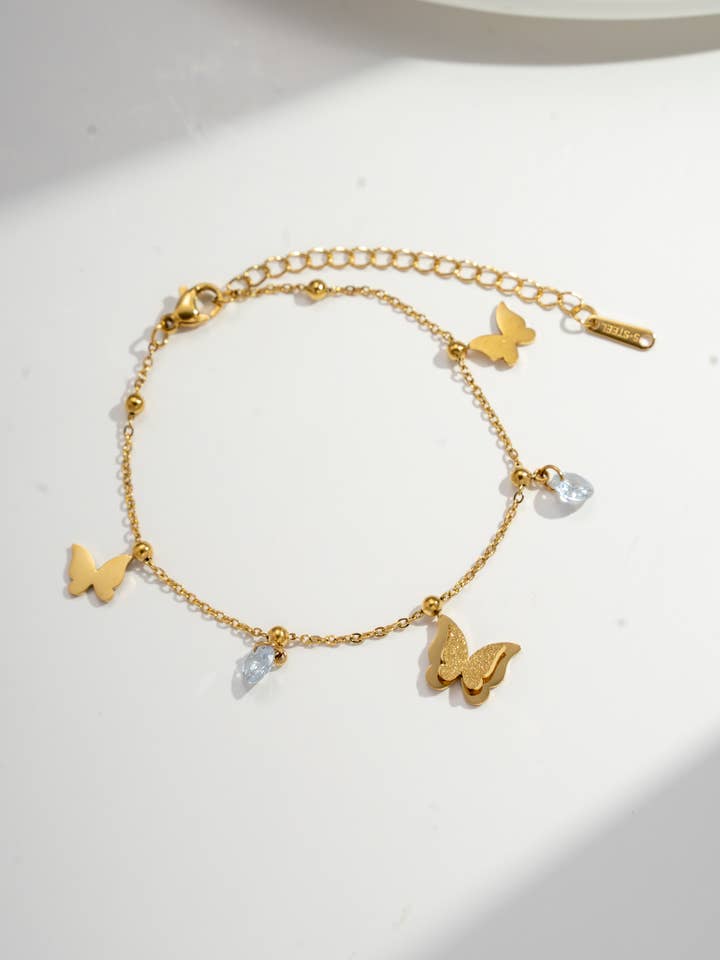 Sommerfugle- og krystalcharmarmbånd i rustfrit stål for engroshandel hos COSMOS