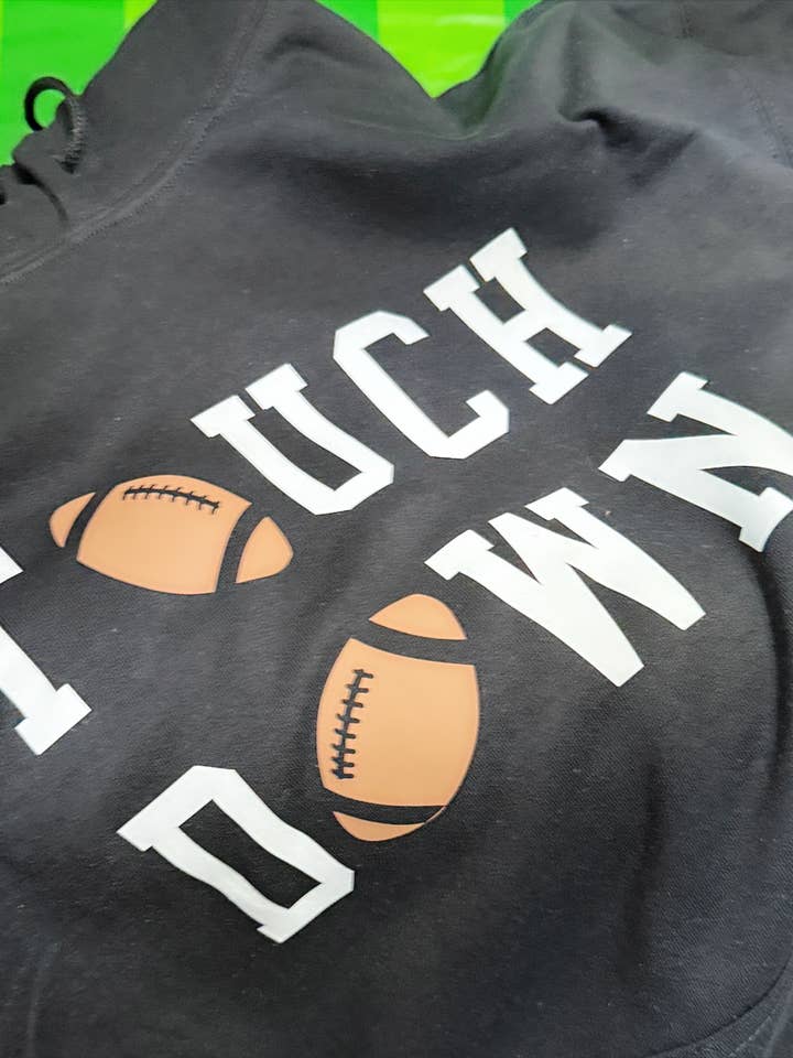 Touchdown Hoodie – Black Pullover with Bold Football Graphic for Game Day Style for wholesale by The Maximalist Boutique