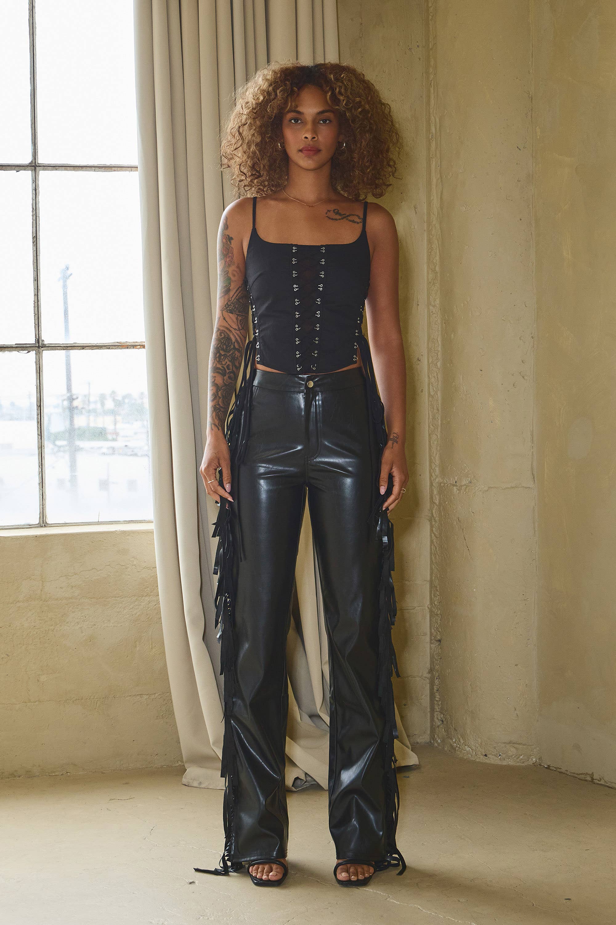 Schwarz Hose mit Seitenfransen aus Kunstleder und ausgestelltem Bein für den Großhandel auf Faire1