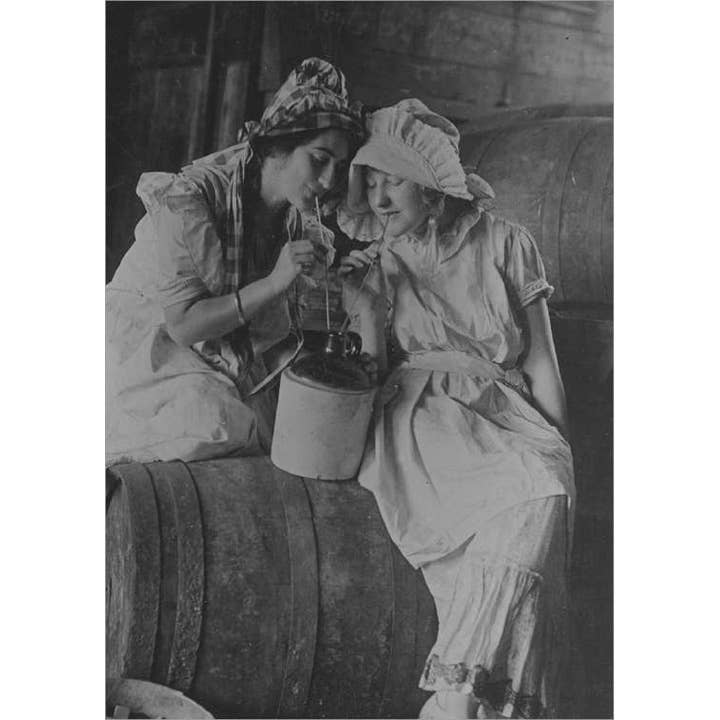 Zwei Frauen trinken aus einem Krug, um 1900. für den Großhandel von Retrospect Greeting Cards