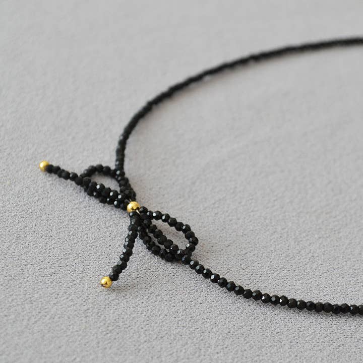 Revelari - Wholesale Beaded/pearl necklace - Black Beaded Necklace with Gold Bow Detail2
