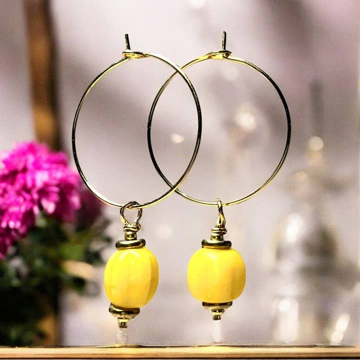 "AMALINA" oorbellen met gouden Afrikaanse gele kralen, verguld en staal voor wholesale door TOURMALYN