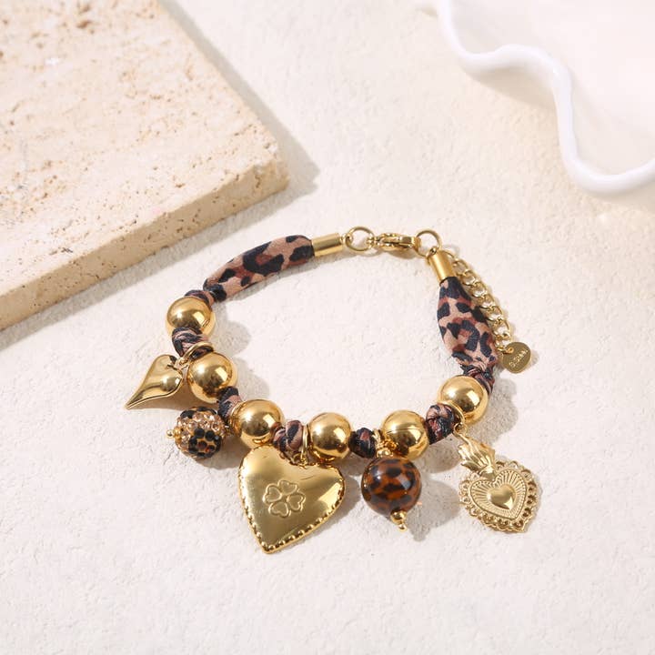 Wide golden bead bracelet adorned with leopard fabric and charms for wholesale by JOYA