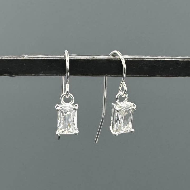 Orecchini pendenti con baguette in CZ incastonati a griffe in argento per la vendita all'ingrosso da parte di Something Silver