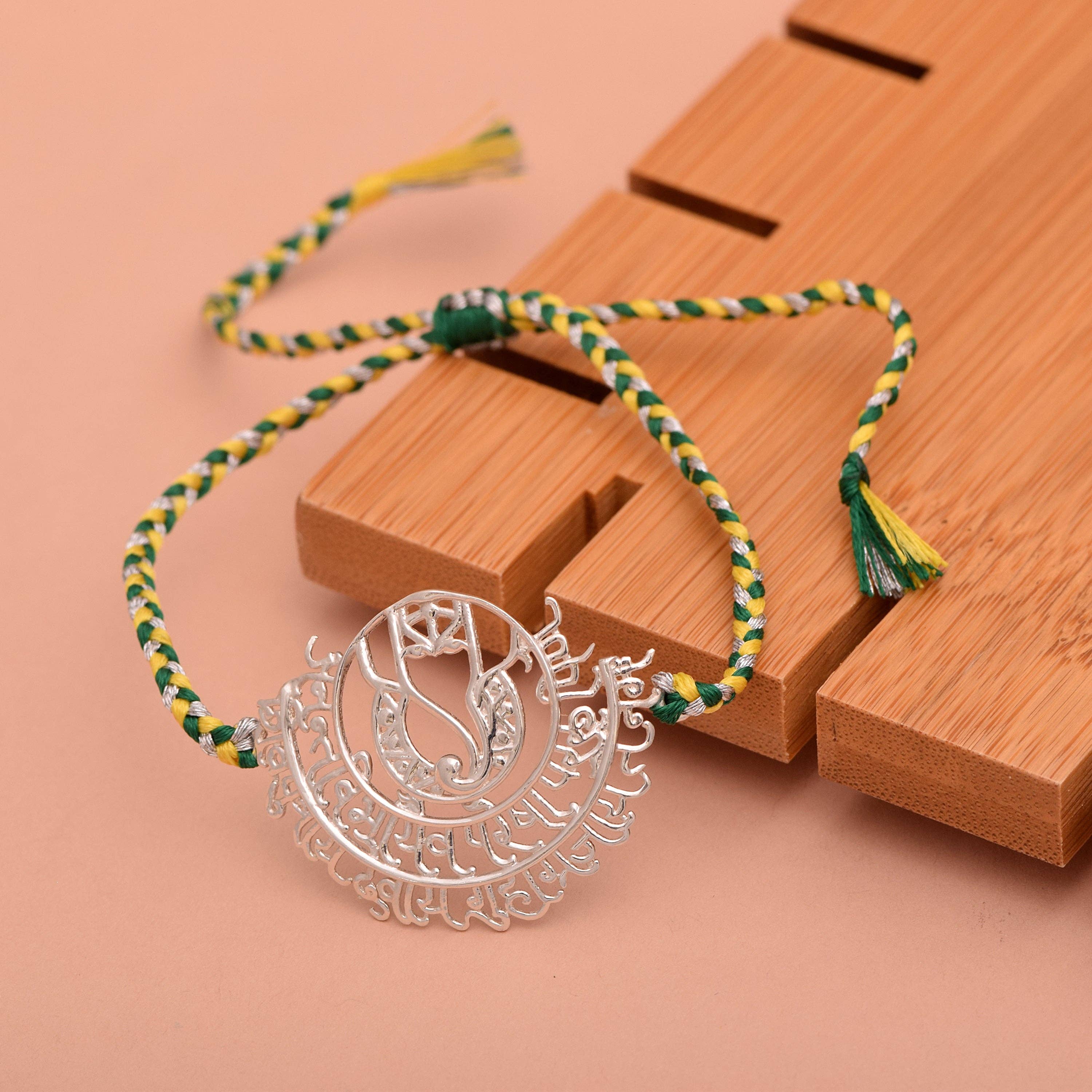 White 925 Sterling Silver Rakhi Green-Yellow Thread Bracelet, Sacred Om Rakhi Intricate Silver Charm on Handwoven Rakshabandhan Bracelet for wholesale on Faire3