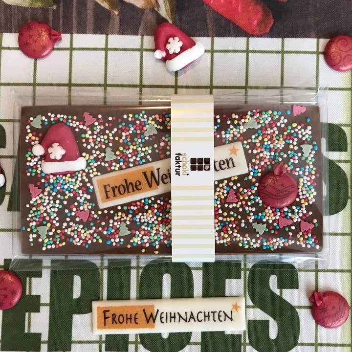 Chocolate bar with Christmas hat, Christmas bauble (red), and sugar decoration for wholesale by Schokifaktur