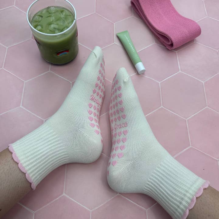 Cream sock with a pink ruffle and pink heart grips for wholesale by MollyGraceGripSocks
