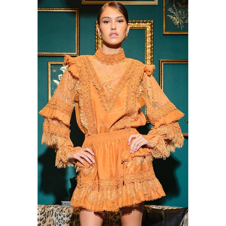 Blusa in pizzo floreale con collo alto e maniche a volant per la vendita all'ingrosso da parte di INA