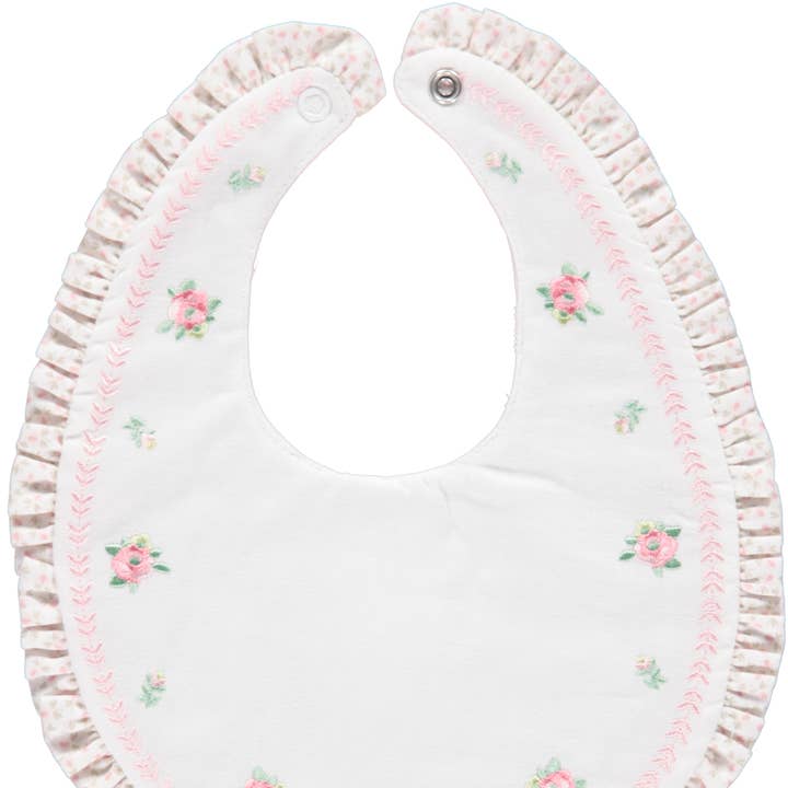 Rosa White and pink bib with floral embroidery and ruffle details for wholesale on Faire0
