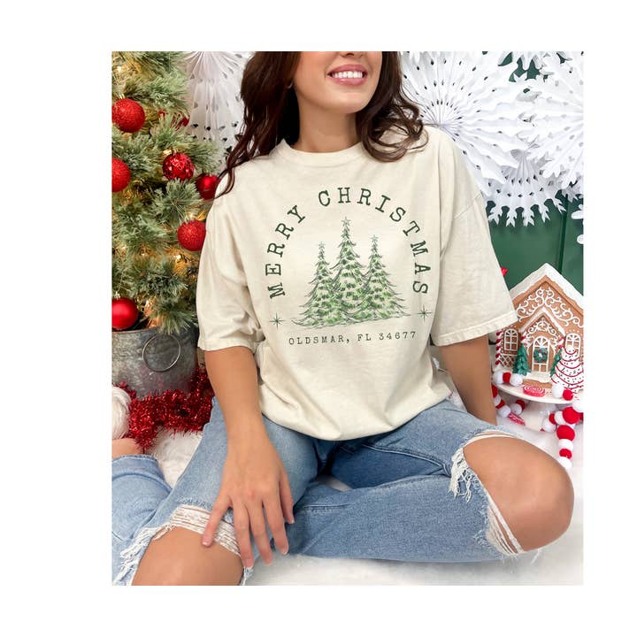 T-shirt graphique personnalisé "Joyeux Noël" avec arbres et ville/village pour la vente par J. Mack Designs