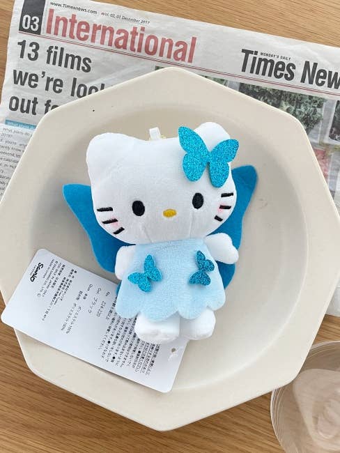 Porte-clés Snuggy – Peluche Hello Kitty en robe papillon bleue pour la vente par MOND HAUS
