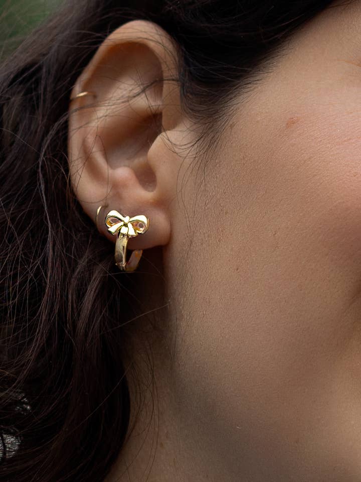 Bow and Tell Huggie Hoops - 18K Gold Plated for wholesale by Peter and June