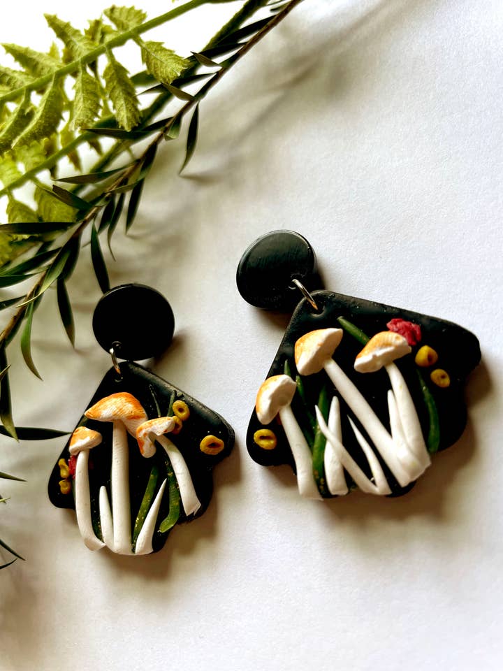 Boucles d'oreilles en pâte polymère St. George Mushroom avec feuillage pour la vente par the Pale Porchlight