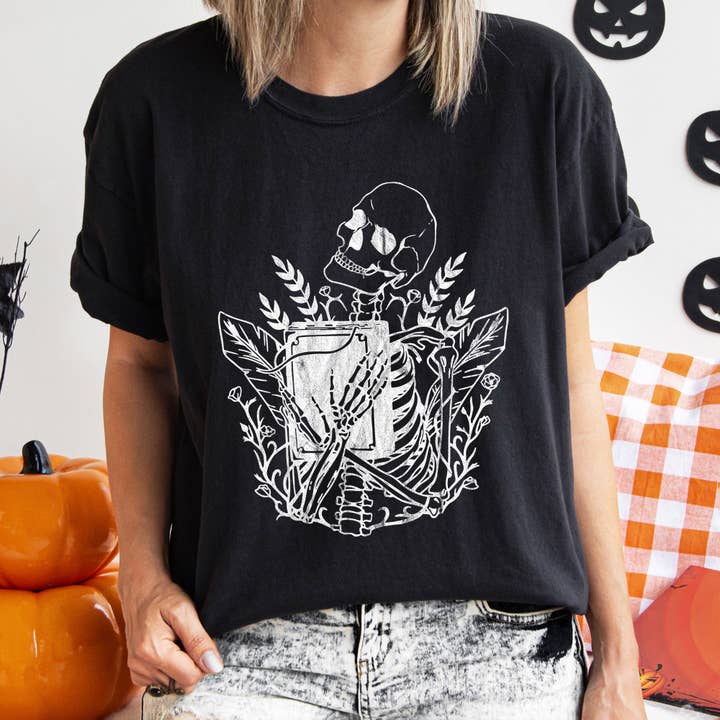 Skeleton And The Book Retro Halloween-T-shirt met witte print voor wholesale door Refinery Number One LLC