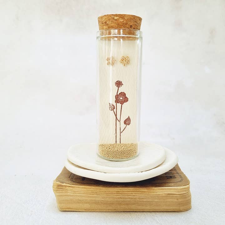 Gold flower stud earrings in a bottle for wholesale by Zamsoe