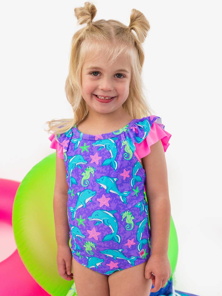 Bañador de una pieza con lazo en la espalda en V y diseño de aletas de neón para niñas. para venta al por mayor de RuffleButts + RuggedButts