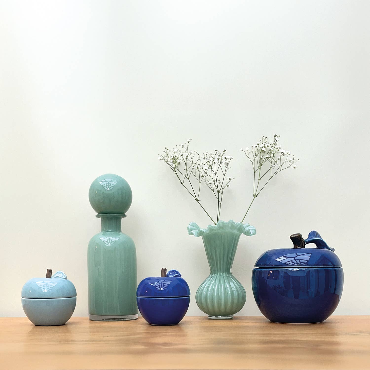 Opjet Paris – Großhandel Kerze im Glas / gefüllte Kerze – Duftkerze in blauer Apfelform, Bernstein-Duft, D 9,8 cm, H 10,2 cm1