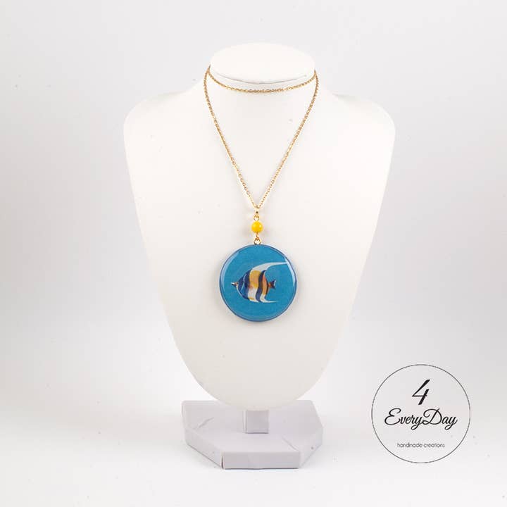 Handcrafted wooden medallion with resin fish on a blue background for wholesale by 4everyday Handmade