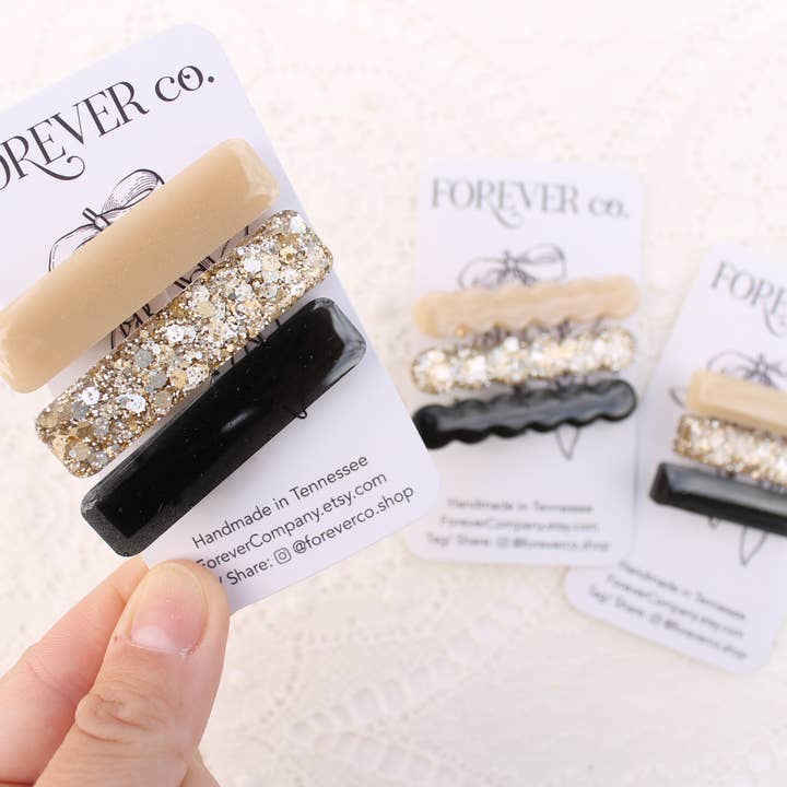Set fermagli per capelli in resina glitterata dorata neutra mista con nero per la vendita all'ingrosso da parte di Forever Company