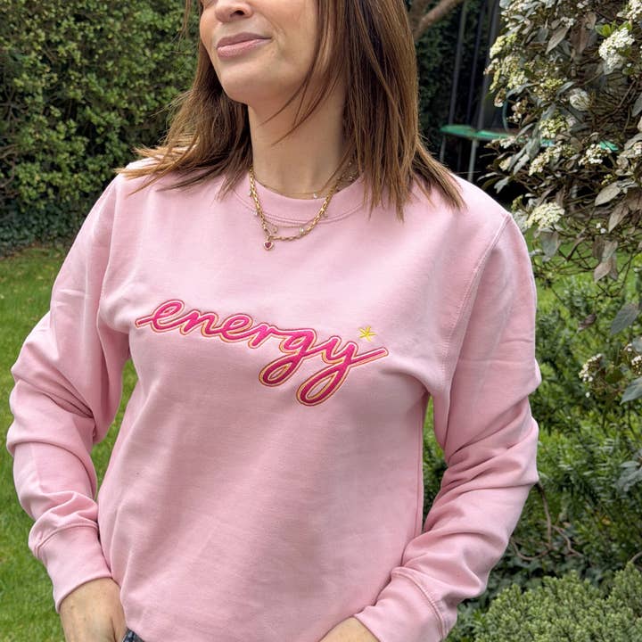 Sweat-shirt rose avec le slogan « Energy » brodé pour la vente par Percy and Nell Retail Limited
