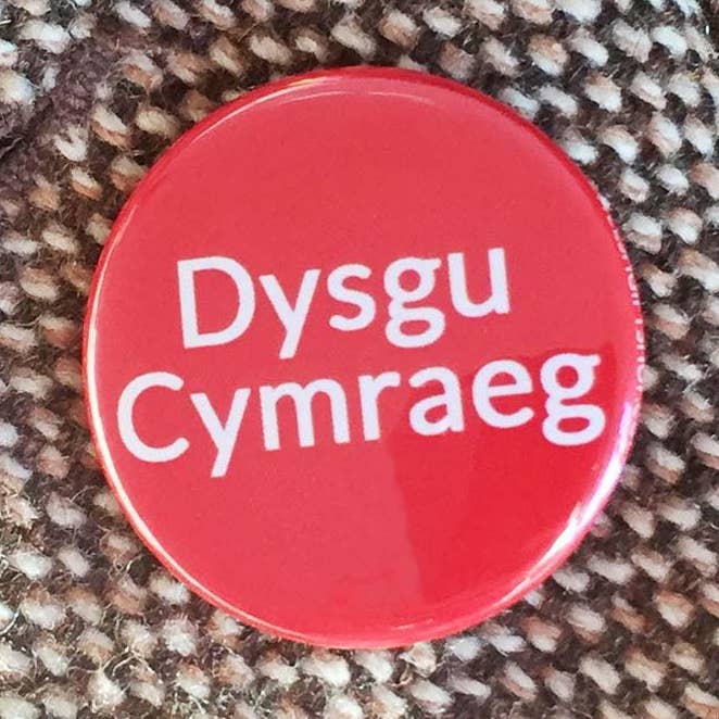 Badge / Pin - Dysgu Cymraeg / Learning Welsh for wholesale by The Welsh Gift Shop