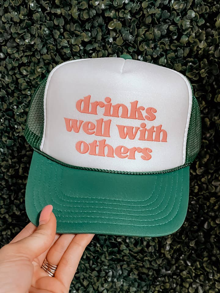 'Drinks Well With Others' Trucker hat for wholesale by Teal West Boutique