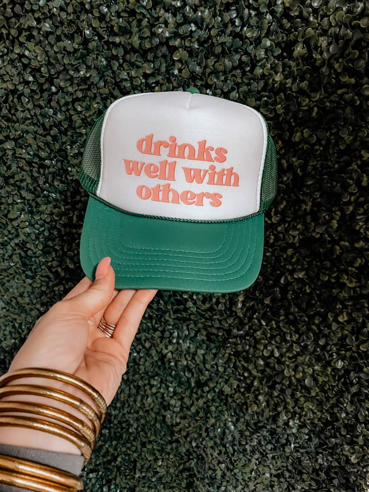 Casquette de camionneur « Drinks Well With Others » pour la vente par Teal West Boutique