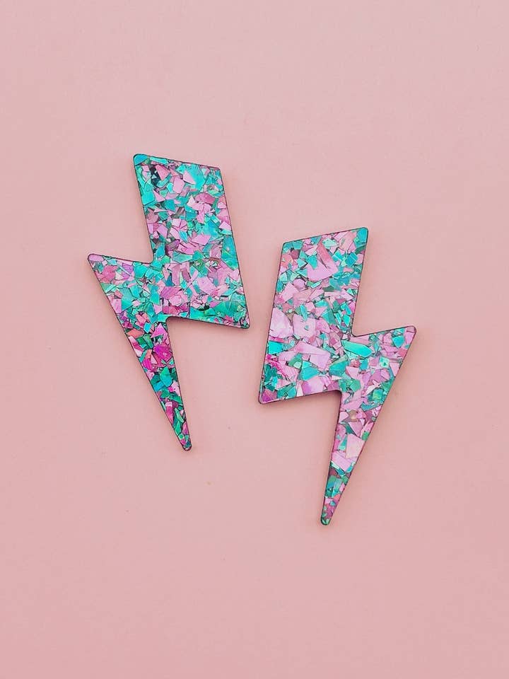 Maxi glitter oorstekers in bliksemschichtvorm groen/paars voor wholesale door Studio Annette