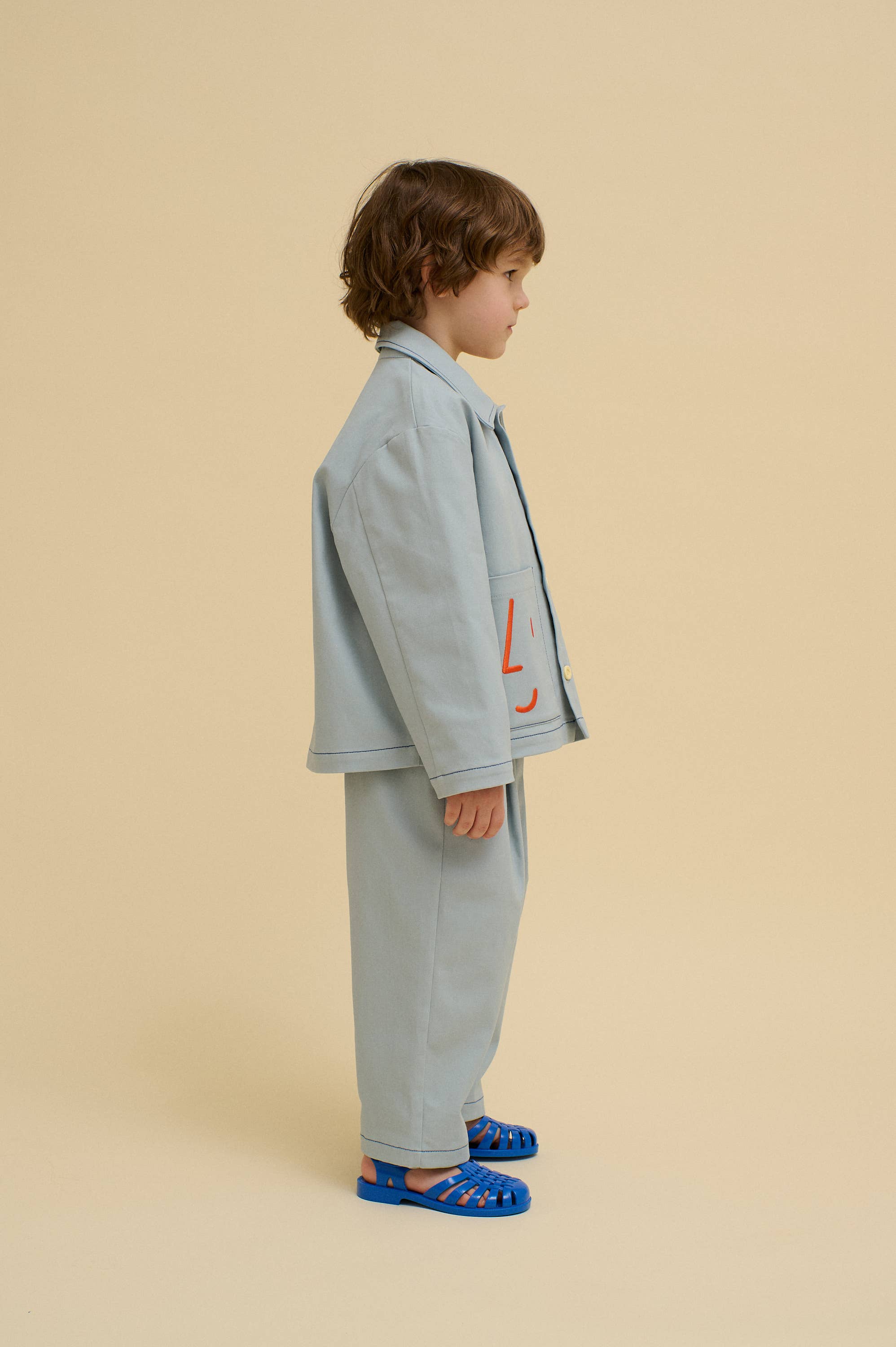 Blauw Utility jas met speelse geborduurde gezichten voor groothandel op Faire3