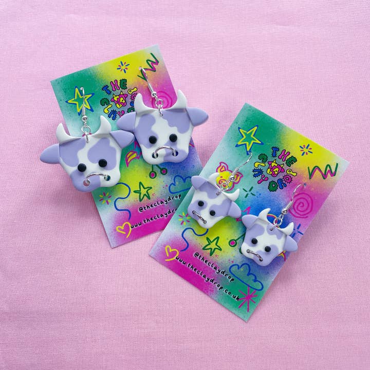 Pendientes de arcilla polimérica de vaca morada y blanca - 2 tamaños para venta al por mayor de The Clay Drop