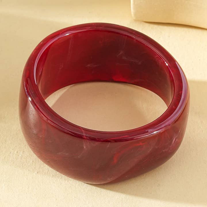 Thick bangle bracelet with rounded shape in burgundy resin for wholesale by joya