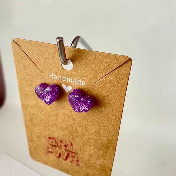 Orecchini a bottone a forma di cuore con glitter color lavanda per la vendita all'ingrosso da parte di GRL PWR Jewelry