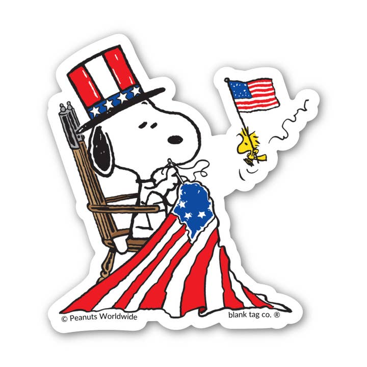 Peanuts® Waterproof Sticker - Snoopy Sewing A Flag for wholesale by Blank Tag Co. - Waterproof Stickers