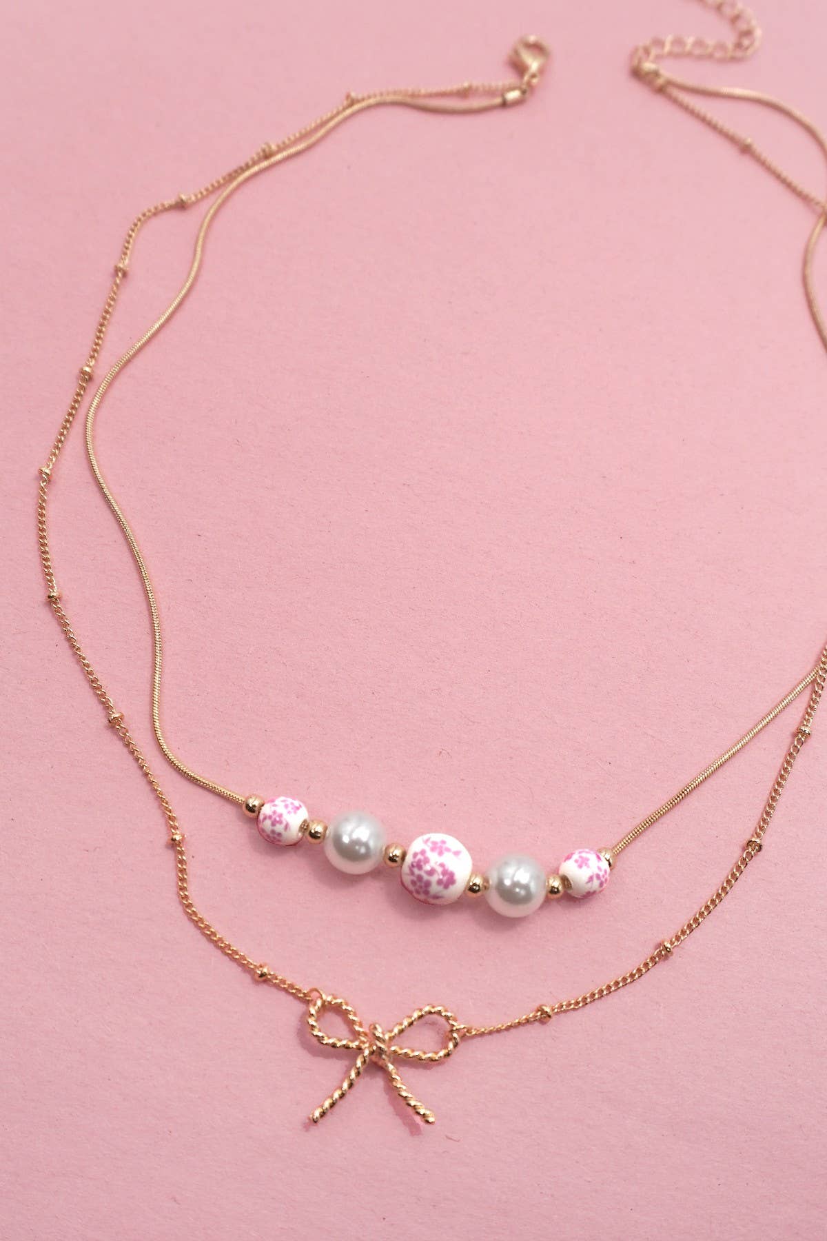 Gold PINK CERAMIC PORCELAIN PEARL BOW LAYER NECKLACE | 80N91556 for wholesale on Faire1