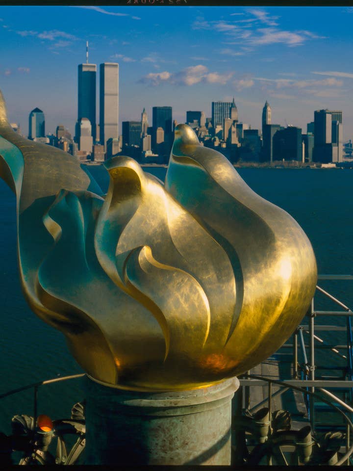 New Torch och Flame med Manhattans skyline i bakgrunden, 17 december 1985. Frihetsgudinnan för wholesale av Print Collection