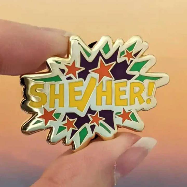 She/Her pronouns hard enamel pin for wholesale by Cunning Linguist Co.