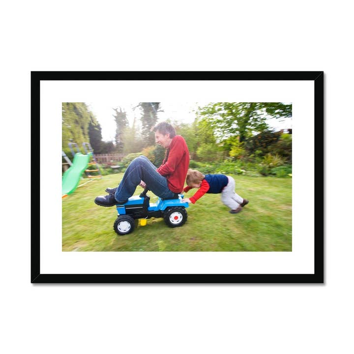 Jonge jongen duwt zijn vader op een tractor Framed & Mounted Print voor wholesale door Sorbey
