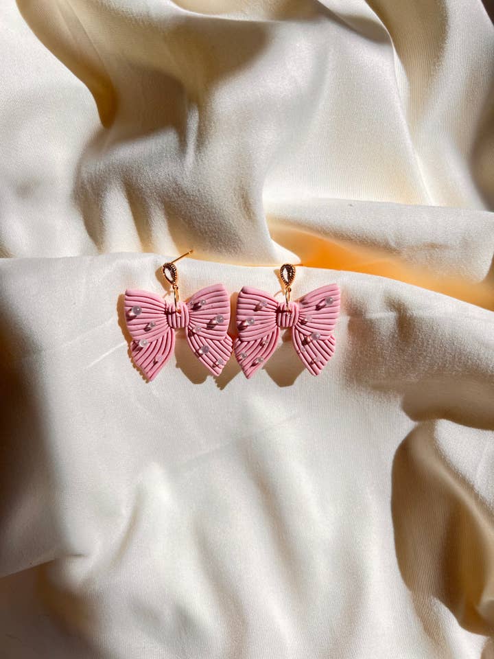 Orecchini fiocco rosa per la vendita all'ingrosso da parte di Artezina & Co.