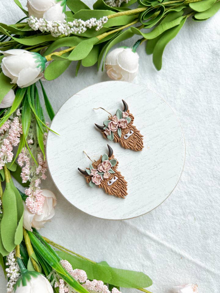 Boucles d'oreilles en argile polymère Vache Highland avec couronne florale pour la vente par Morning Dew Designs