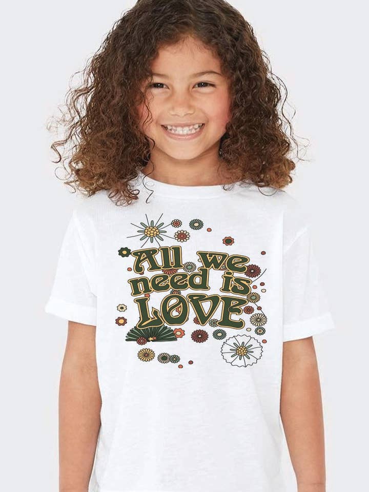 L1400 - GRAFISK T-SHIRT MED "ALT VI BEHØVER ER KÆRLIGHED" for engroshandel hos KNOCK ON THE STYLE