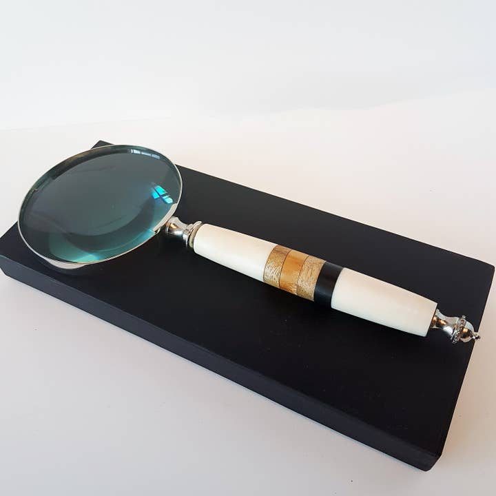 Magnifying glass in off white with an inlaid wood handle. for wholesale by Galerie Indra