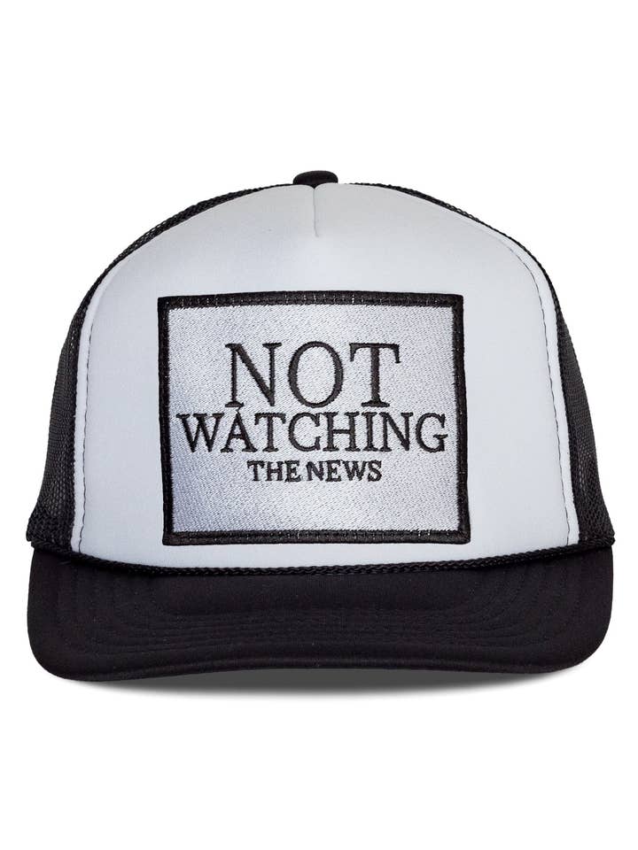 Not Watching The News Trucker Hat in Black and White Split for wholesale by Friday Feelin'
