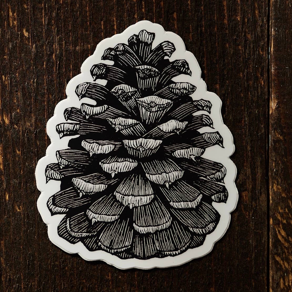 Ponderosa pinecone linocut sticker for wholesale by Anomal Press