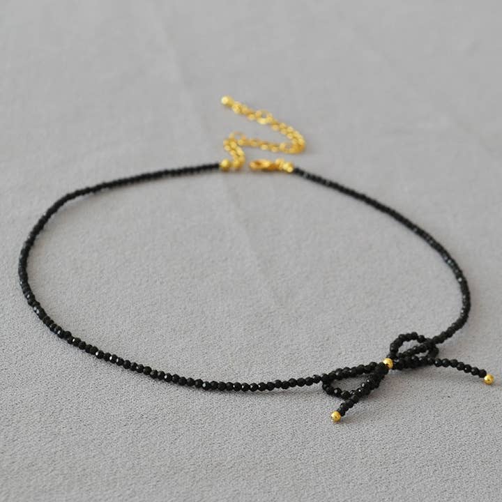 Revelari - Wholesale Beaded/pearl necklace - Black Beaded Necklace with Gold Bow Detail1