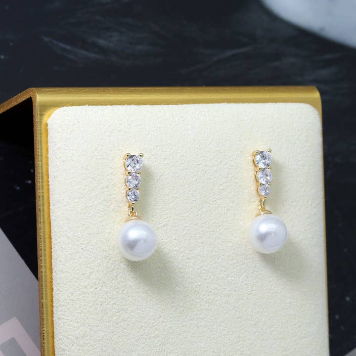 Brincos de pérola de ouro CZ, jóias de noiva, Sku #ZX100 e outras tendências em Compre jóias em prata B2B. Devoluções gratuitas e condições de pagamento a 60 dias na Faire na Faire.