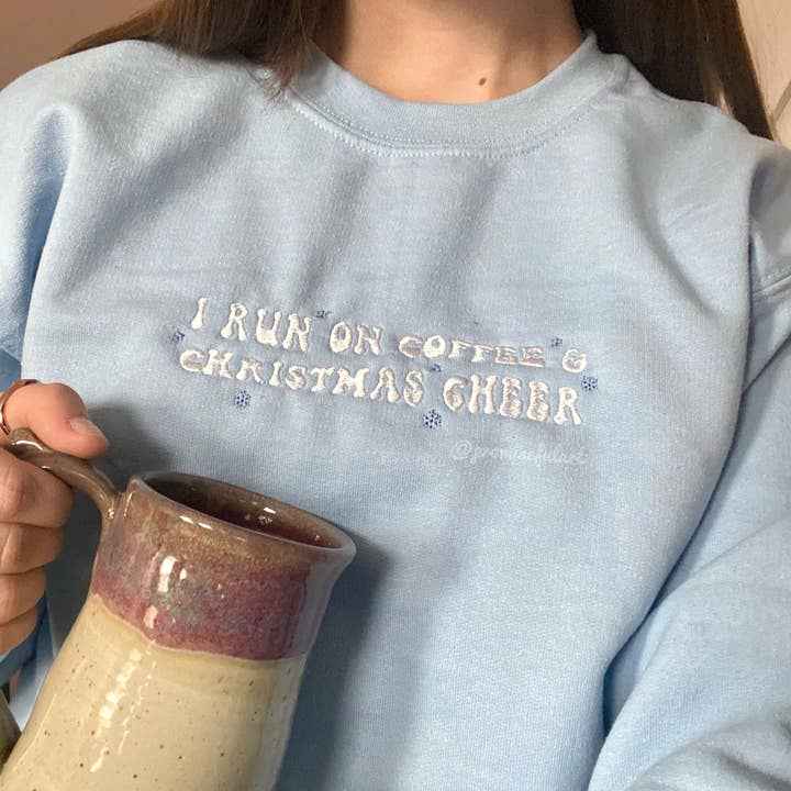 Pull ras du cou brodé « I run on coffee & Christmas cheer » pour la vente par Promiseful Art