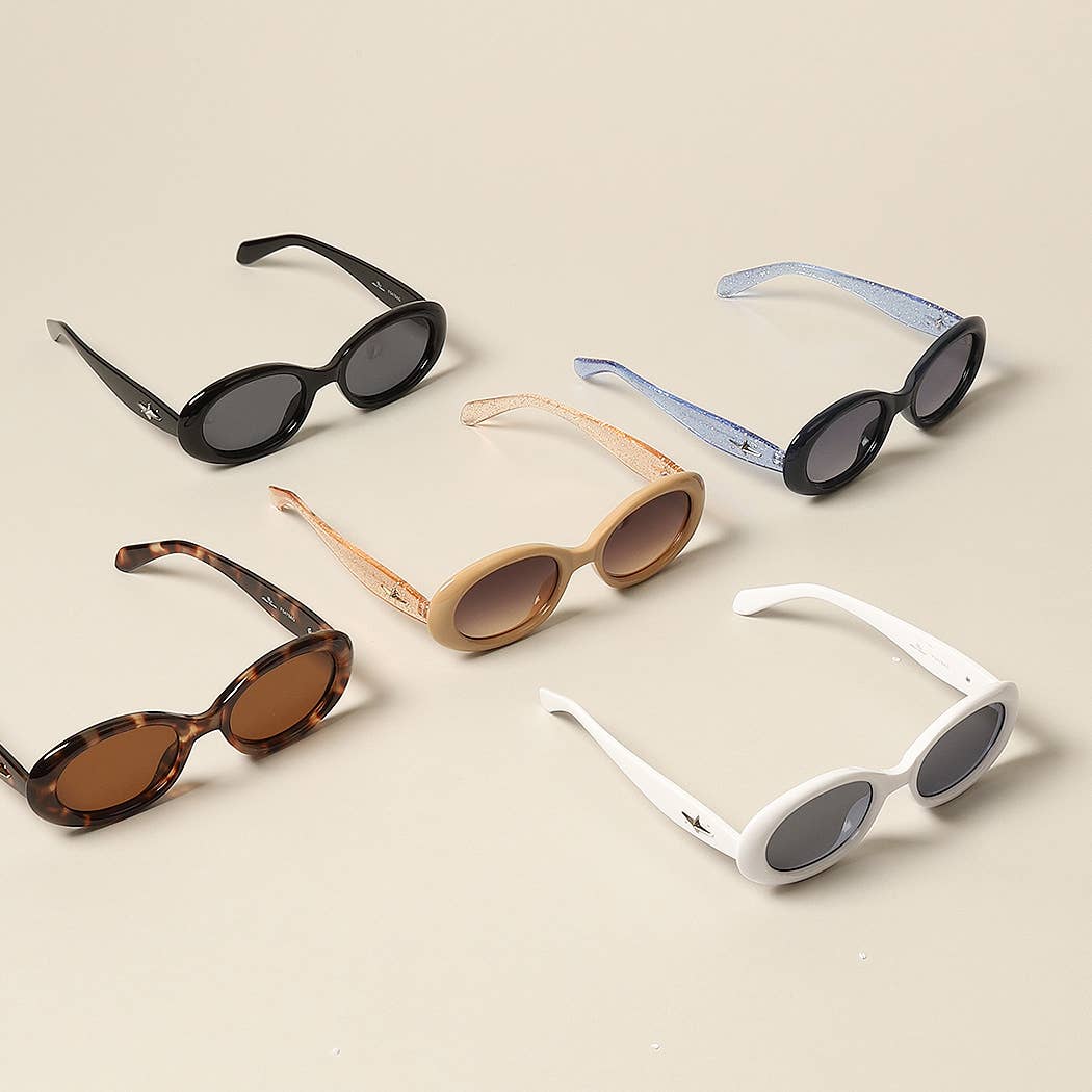 12 CORES SORTIDAS Óculos de sol Oval Glitter da moda para mulher para venda a revendedores na Faire2